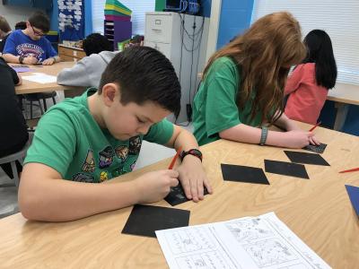 boy and girl creating a scratchboard drawing using scratch tools