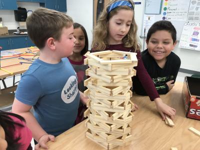 students admire another student's architectural structure