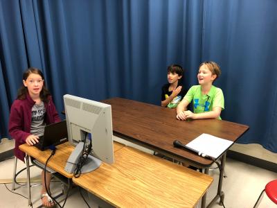 Children practicing a news broadcast