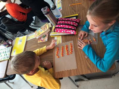 Students working with candy corns to solve multiplication problems. 