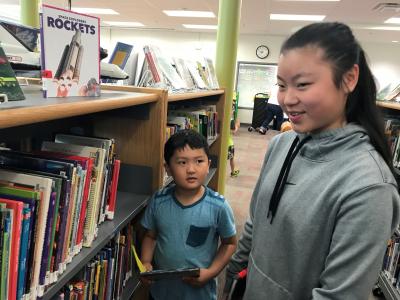 boy and girl checkout books in library