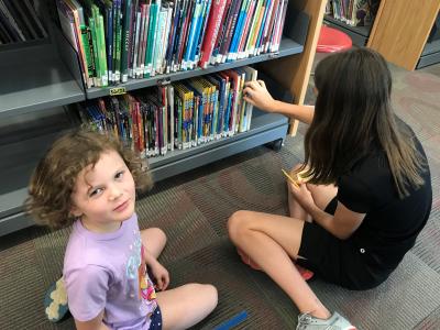 girls look for books in library