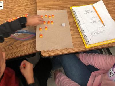 Students working on solving math problems using candy corn