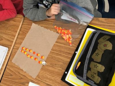 Student working on solving 2x6 with candy corn. 