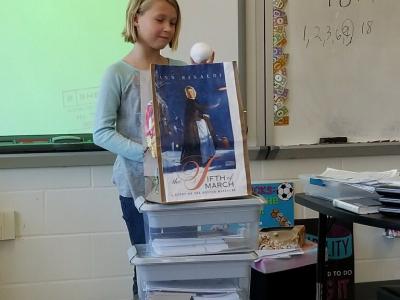 Student shows off her project for "The Fifth of March" by Ann Rinaldi
